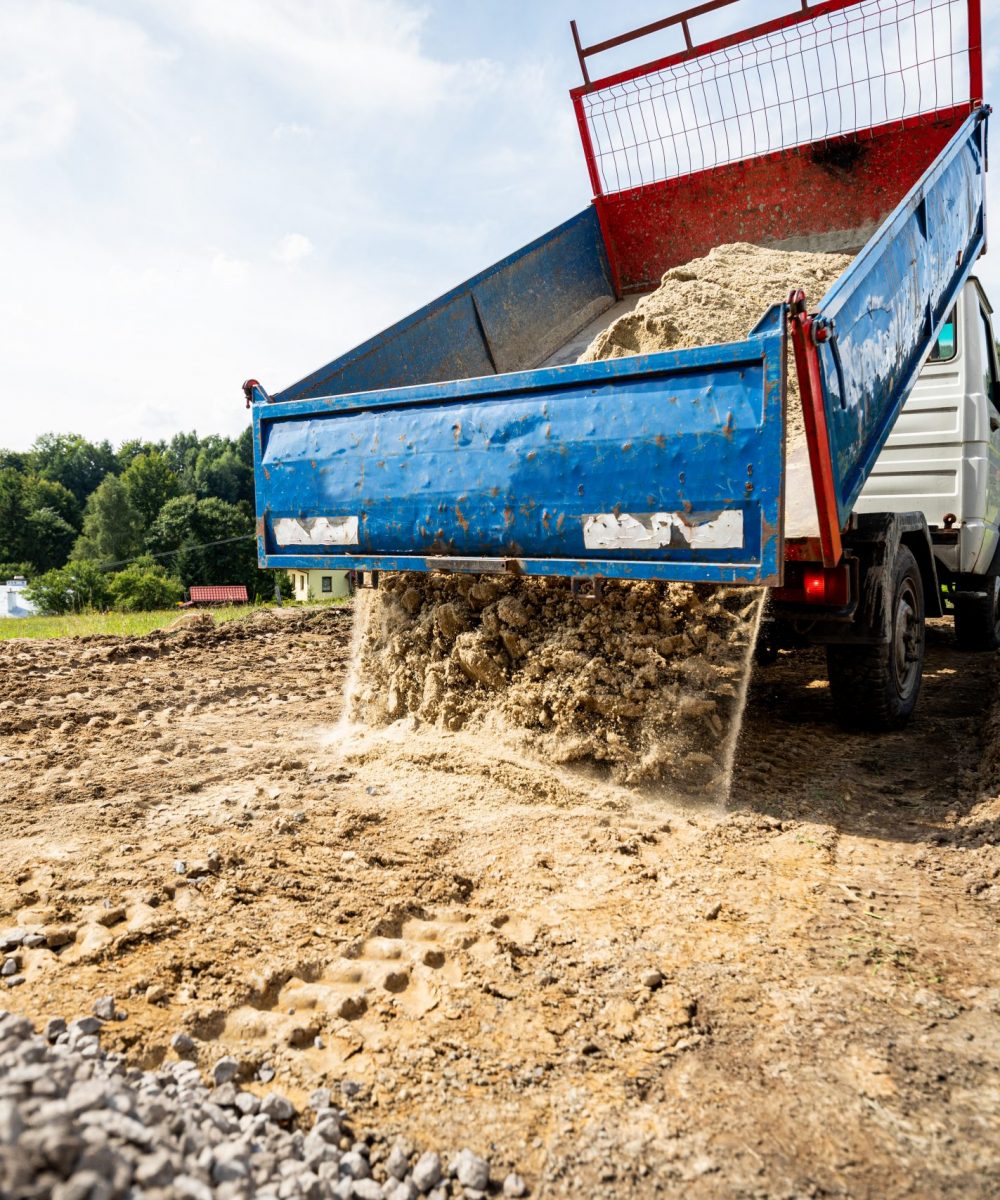 Unloading the truck with the soil and sand at construction site